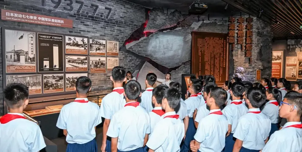 क्या पेइचिंग में 'राष्ट्रीय मुक्ति और विश्व शांति के लिए' थीम प्रदर्शनी का उद्घाटन हुआ?